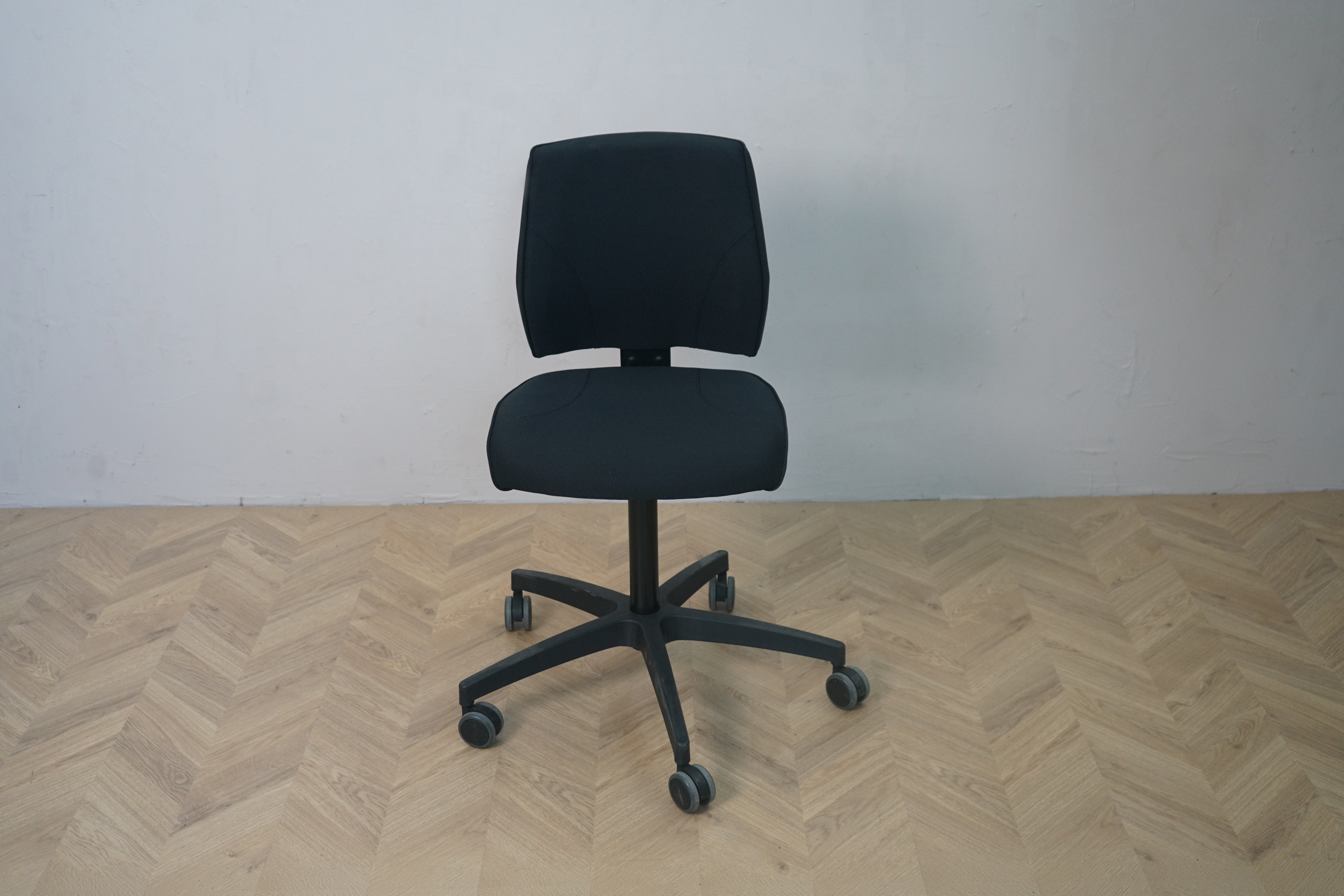 Tronhill kontorstol i sort stof med lav ryg og hjul set forfra – ergonomisk kontorstol